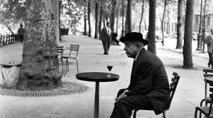 φωτογραφία του ποιητή να κάθεται σε ένα τραπεζάκι καφέ